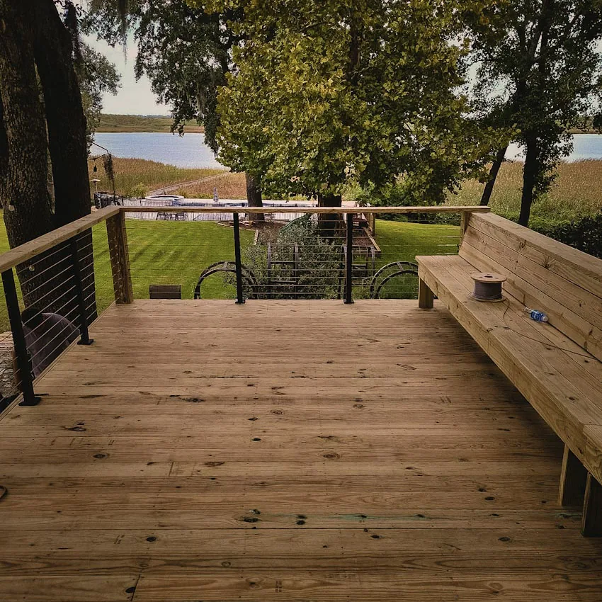 Wood deck with cable railing and a built-in bench facing the water