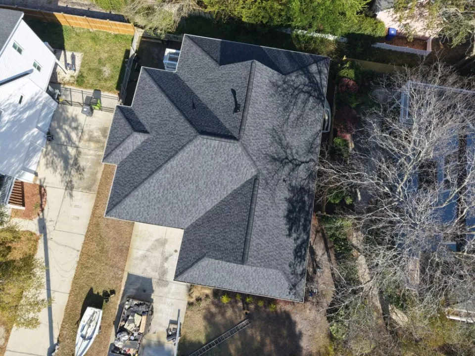 Aerial view of a dark shingle roof with intersecting rooflines