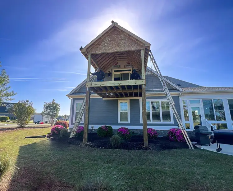 Covered porch addition under construction in Compass Pointe Leland NC by RGR Construction and Roofing with framing and roof structure in progress