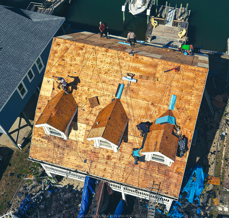 Aerial view of roof replacement in progress on waterfront home in Brunswick County NC by RGR Construction and Roofing, LLC.