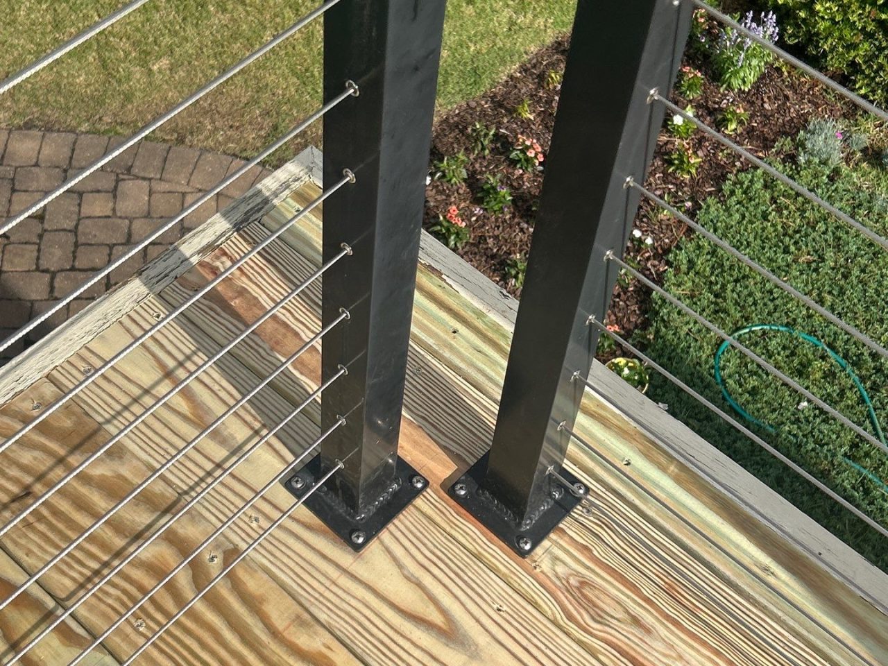 Cable railing posts and cables secured beside timber deck boards at an RGR project in Southport.