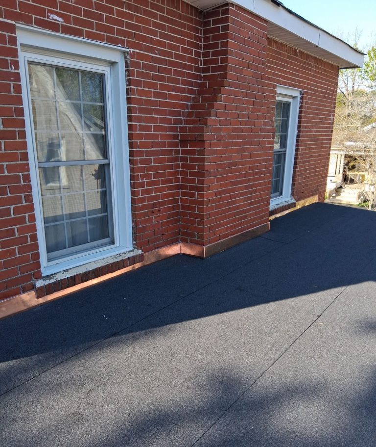 Completed granular flat roof with copper flashing beneath windows on a Wilmington brick home