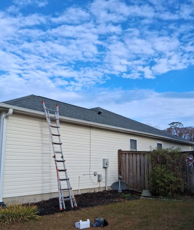 Rear roof slope with a black louver vent and access ladder at the Leland home