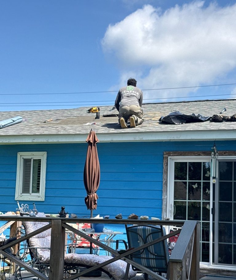 Roof repair underway above a blue-sided Wilmington home, with removed shingles and roofing tools on the slope