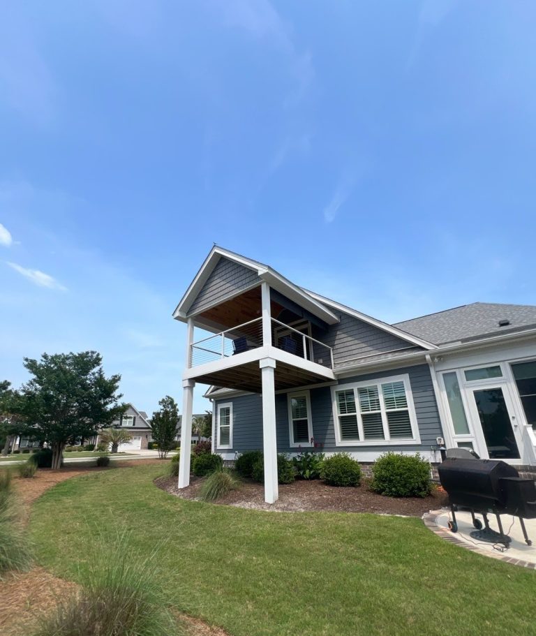 Left-side view of the elevated porch roof and tall support posts at the Leland home