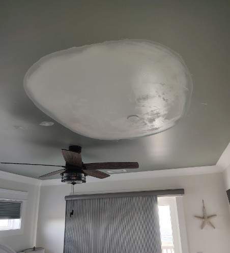 Joint compound covering the repaired ceiling opening beside the bedroom ceiling fan in Oak Island