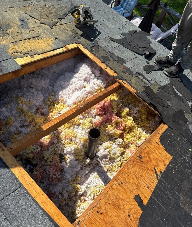 Opened roof decking around a plumbing vent pipe, with framing and insulation exposed during a Wilmington repair