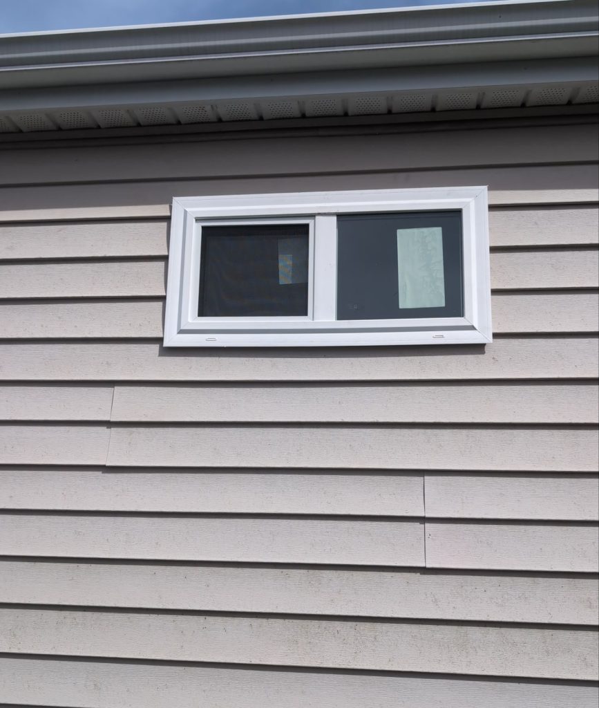 White sliding bathroom window within restored lap siding in Wilmington