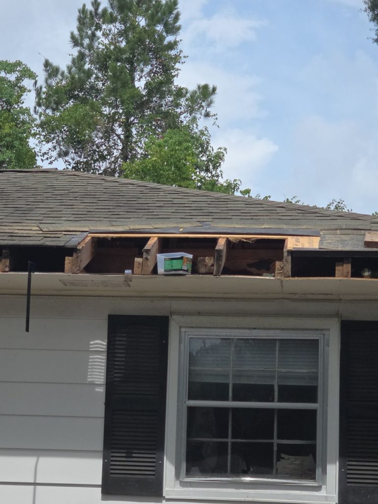 Open fascia area exposing roof-edge framing above the Wilmington window