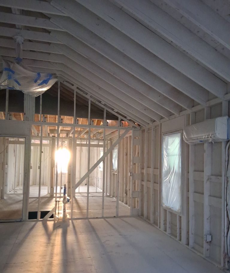 Interior partitions beneath exposed roof rafters during Wilmington home reconstruction