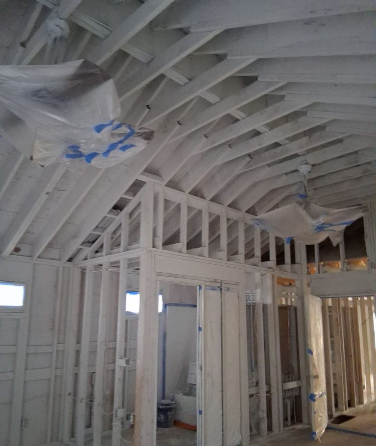 Exposed roof rafters and interior partition framing during Wilmington fire restoration