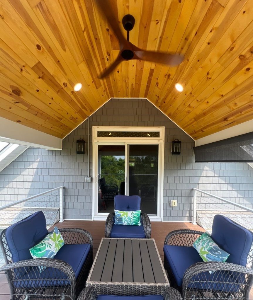 Wood ceiling above the furnished covered porch and cable railing in Leland