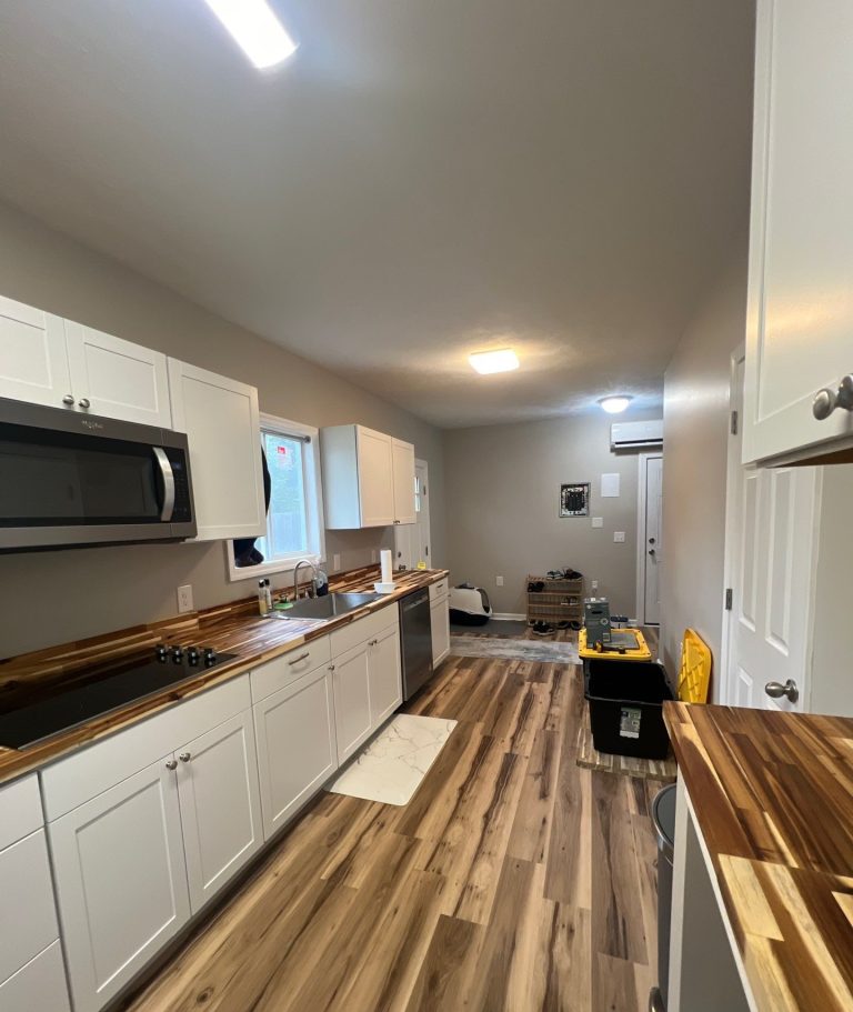 Long kitchen cabinet run and plank flooring in the Belville remodel