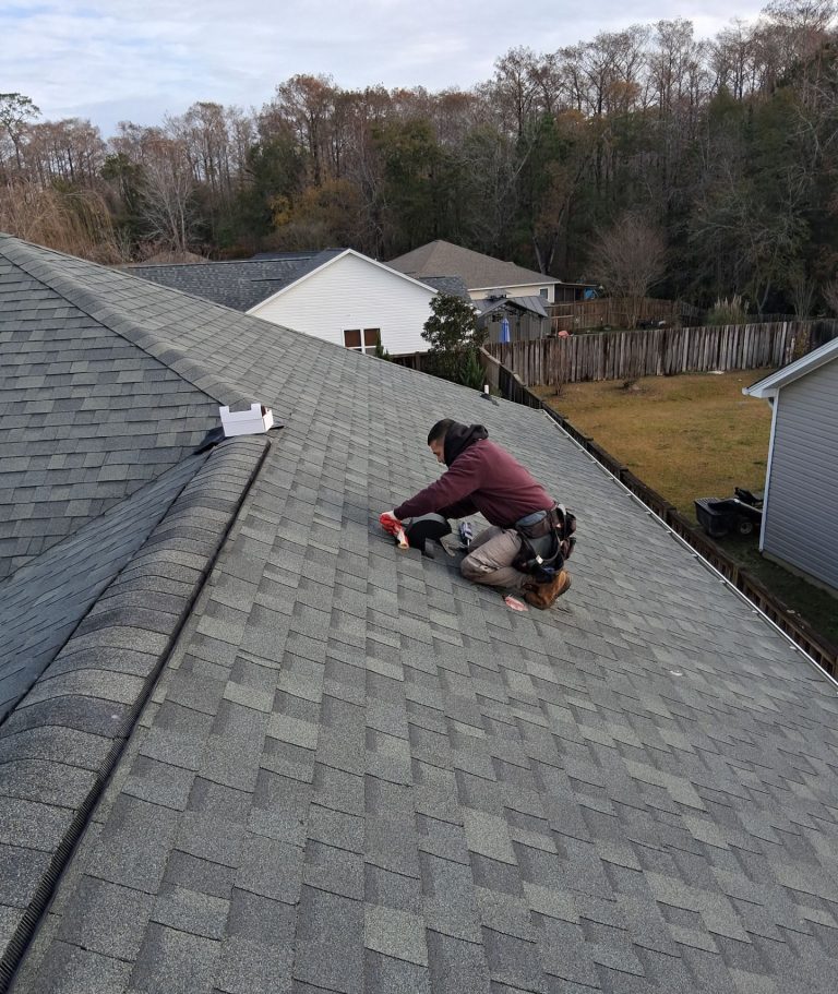 RGR crew member working beside the black louver vent on the Leland roof