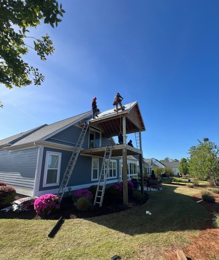 Crew working on the new gable roof above the elevated Leland porch