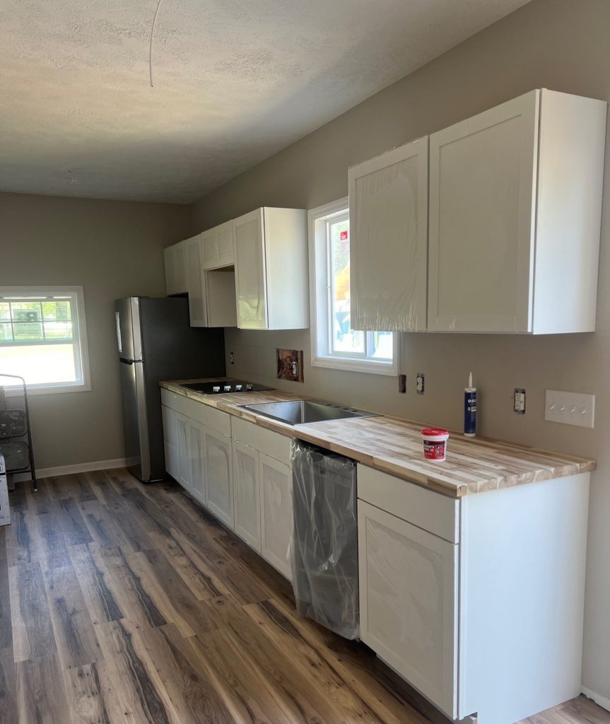 White kitchen cabinets and installed countertops in the Belville home remodel
